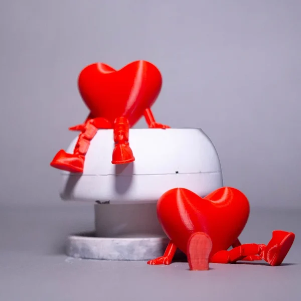 Adorable 3D printed red heart figurines with legs, available now at Print3D.pk.