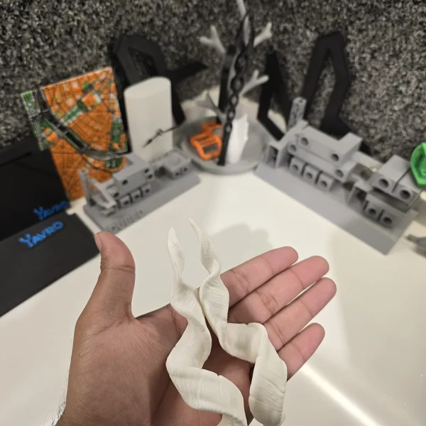 A white 3D printed snake model from Print3D.pk, showcasing detailed texture and flexibility.