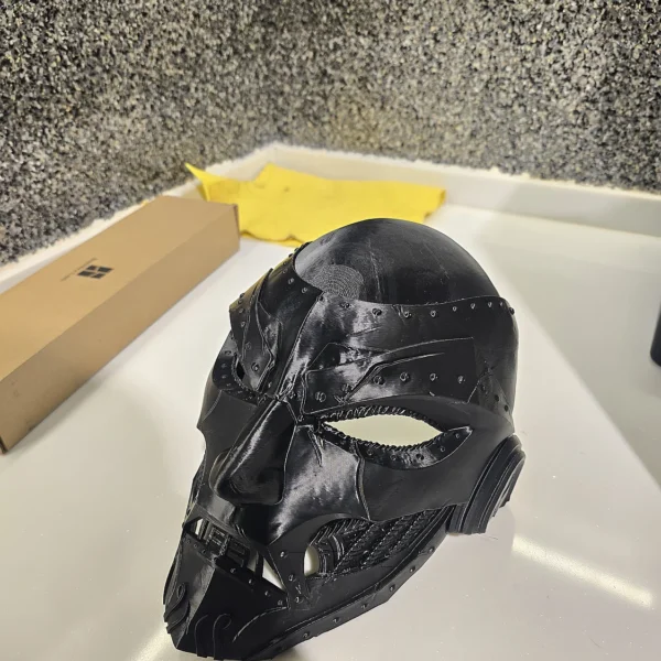Intricately designed black skull face mask, 3D printed with precision by Print3D.pk for a unique look.